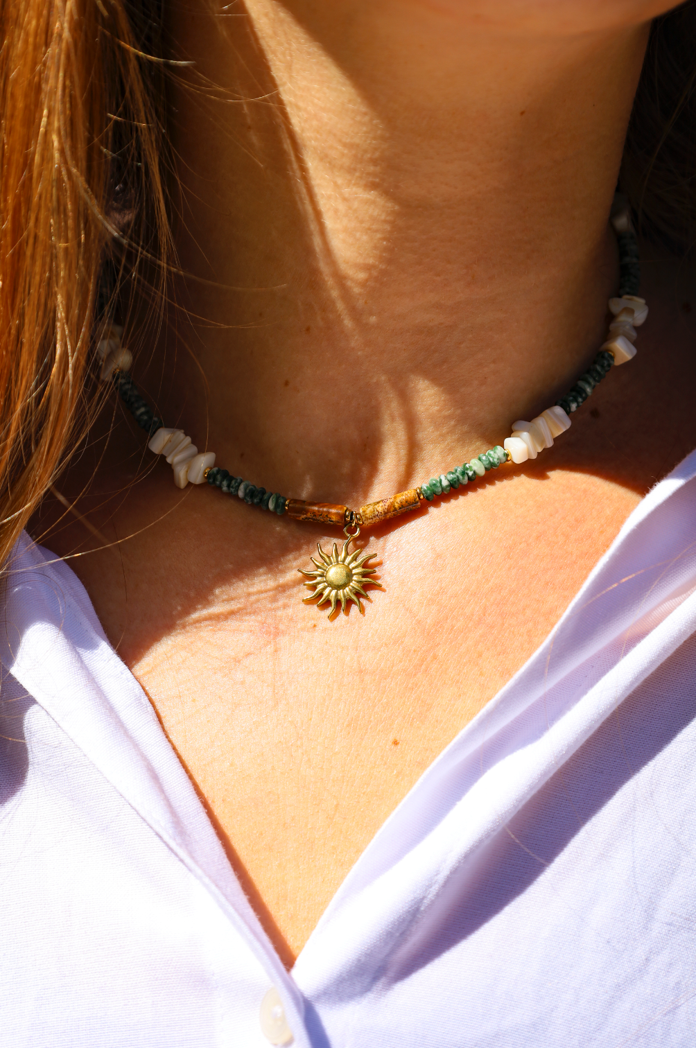 Collier en perles de jades vertes et en perles naturelles blanches avec pendentif soleil.