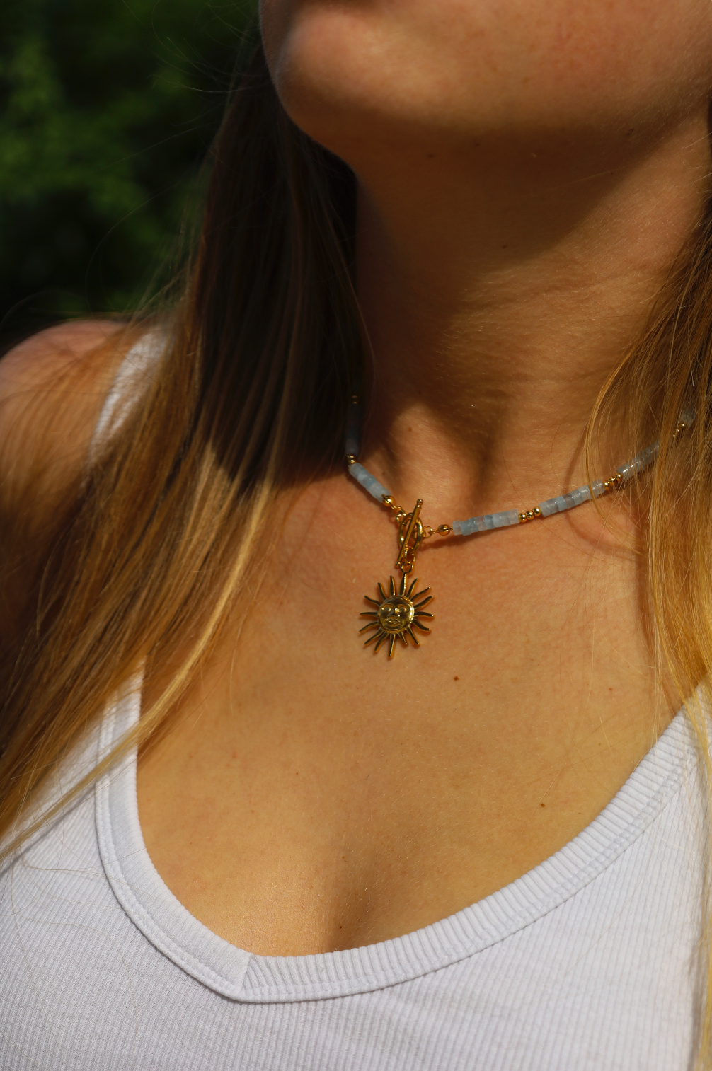 Collier en perles d'aigues marine avec un pendentif soleil en acier inoxydable