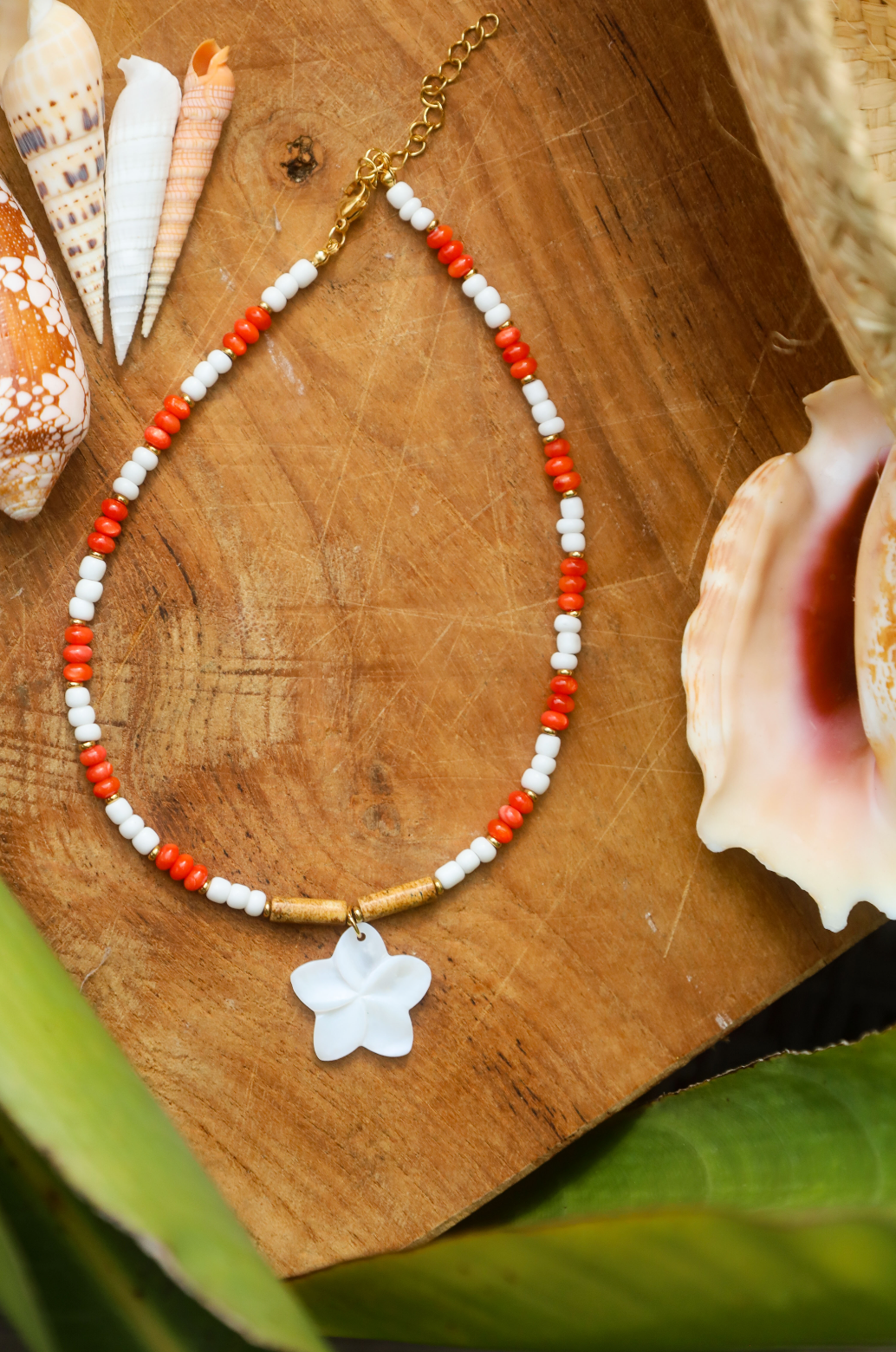 Collier en perles rocailles blanches et rouges avec pendentif en fleur de nacre