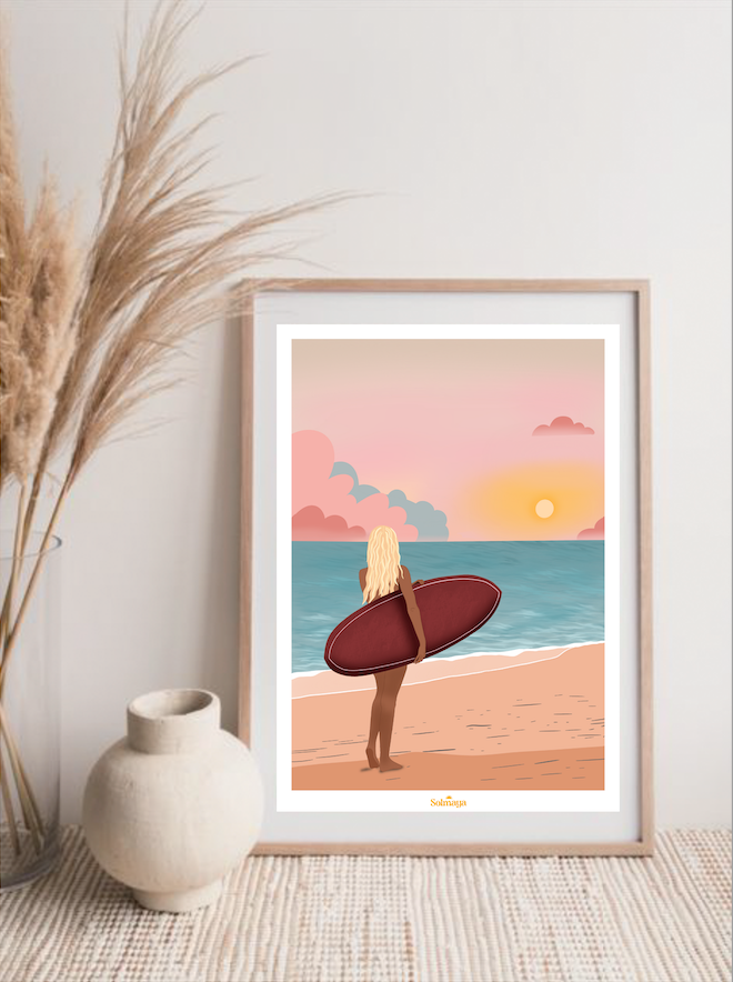 Affiche représentant une femme de dos avec sa planche de surf devant le soleil couchant