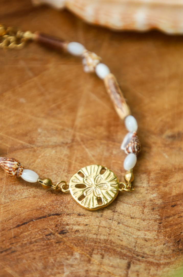 Bracelet avec pendentif dollar des sables et coquillages et bois naturel et perles en nacres.