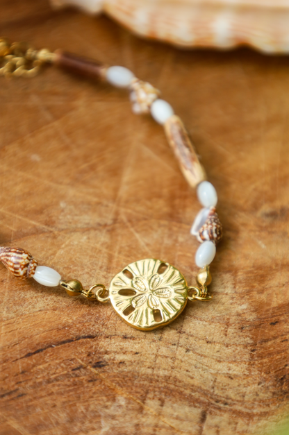 Bracelet avec pendentif dollar des sables et coquillages et bois naturel et perles en nacres.