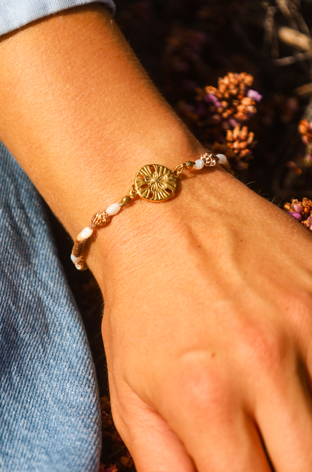 Bracelet avec pendentif dollar des sables et coquillages et bois naturel et perles en nacres.