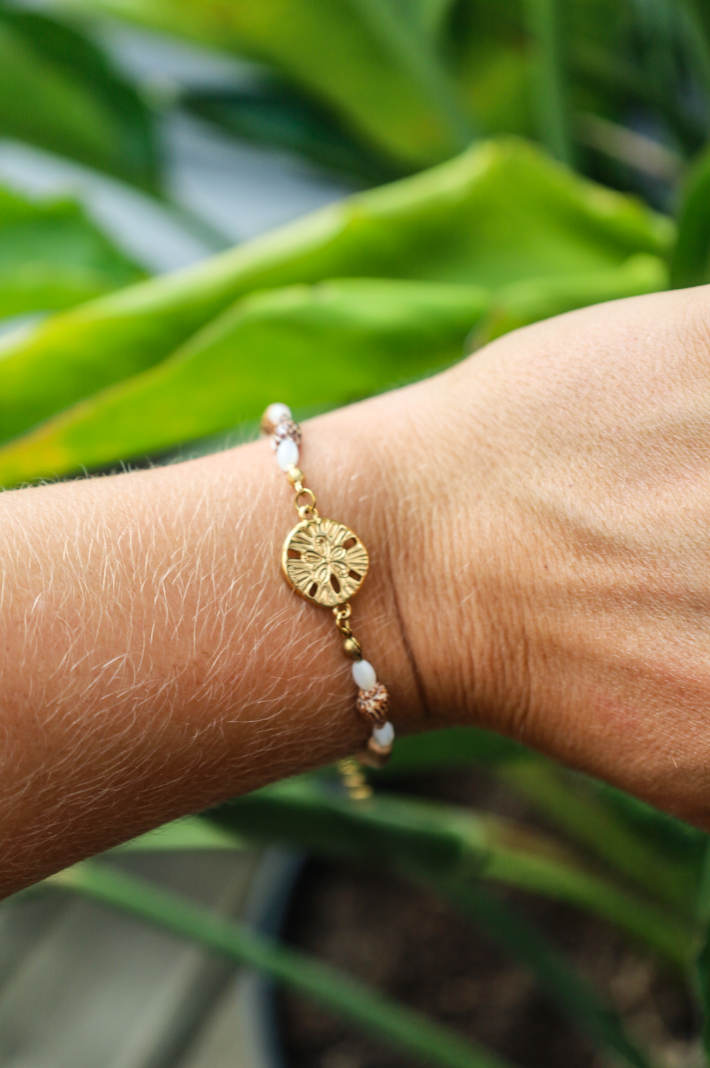 Bracelet avec pendentif dollar des sables et coquillages et bois naturel et perles en nacres.