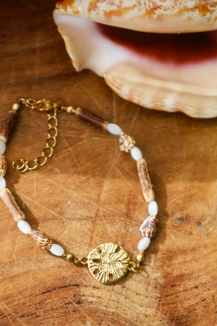 Bracelet avec pendentif dollar des sables et coquillages et bois naturel et perles en nacres.