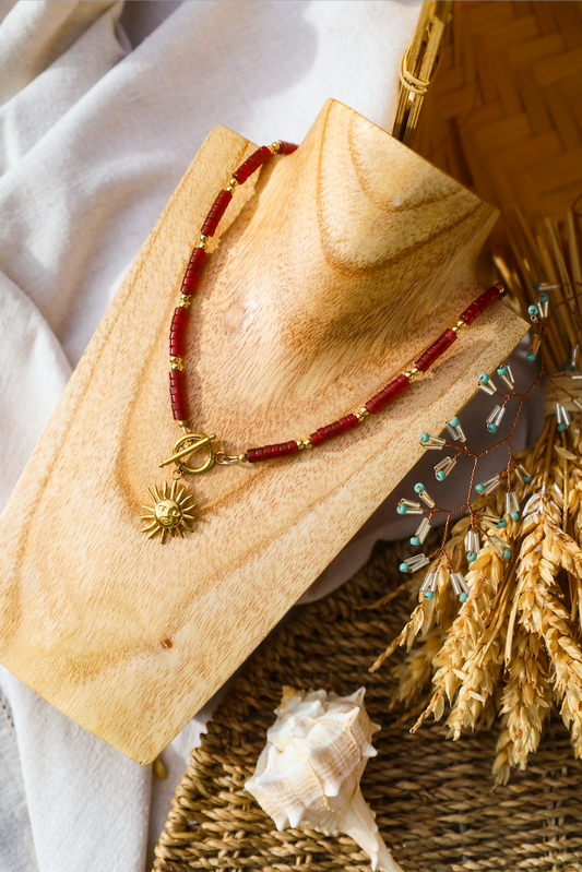 Collier en aciner inoxydable et perles pourpres avec pendentif soleil