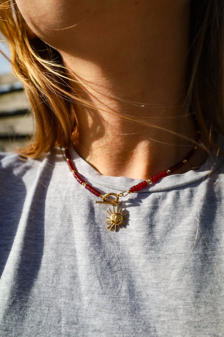 Collier en aciner inoxydable et perles pourpres avec pendentif soleil