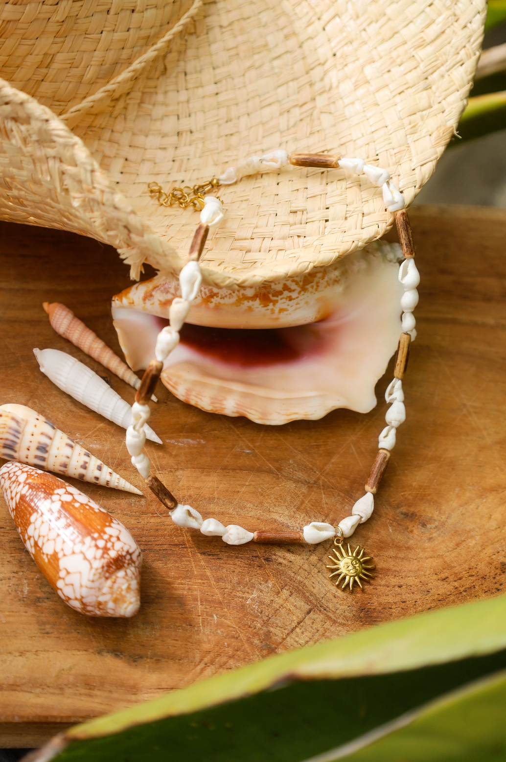 Collier en coquillages blancs et perles en bois naturel avec petit pendentif soleil