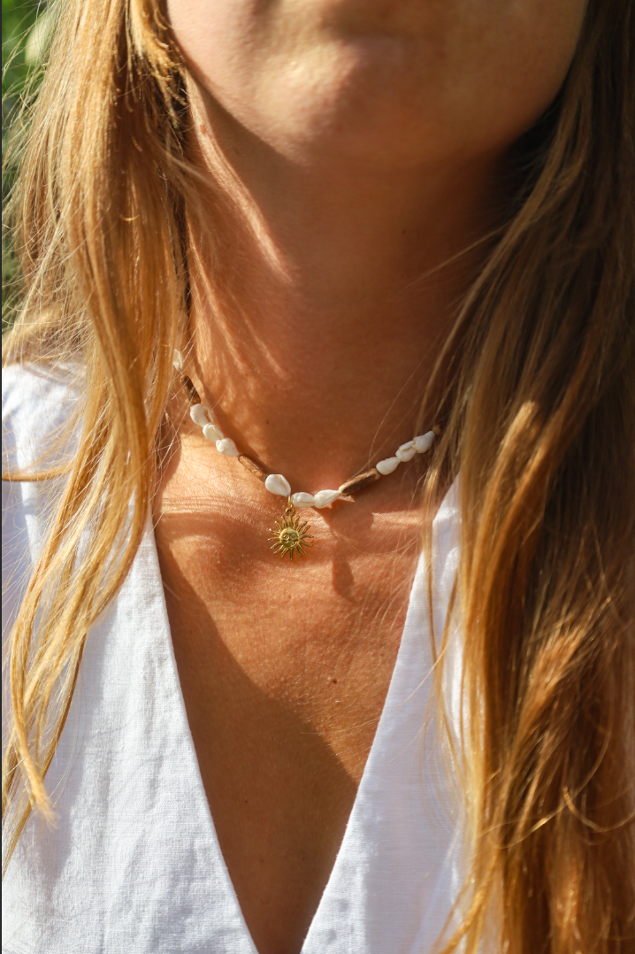 Collier en coquillages blancs et perles en bois naturel avec petit pendentif soleil