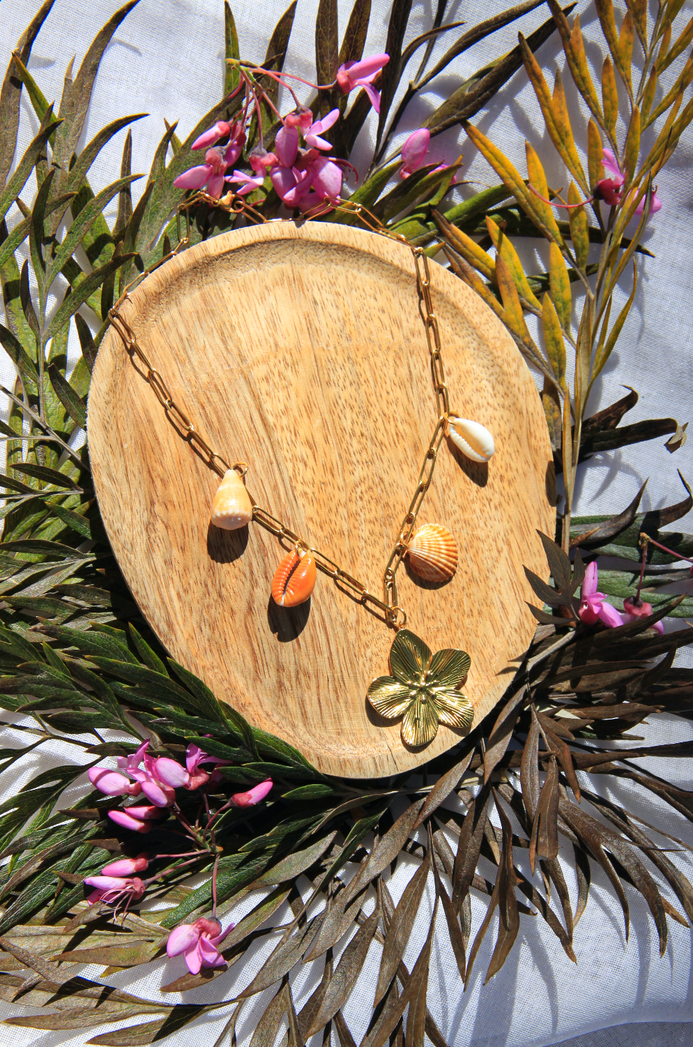 Collier avec chaine en acier inoxydable et 4 coquillages différents avec un petit pendentif fleur