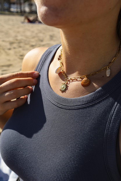 Collier avec chaine en acier inoxydable et 4 coquillages différents avec un petit pendentif soleil