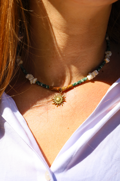 Collier en perles de jades vertes et en perles naturelles blanches avec pendentif soleil.