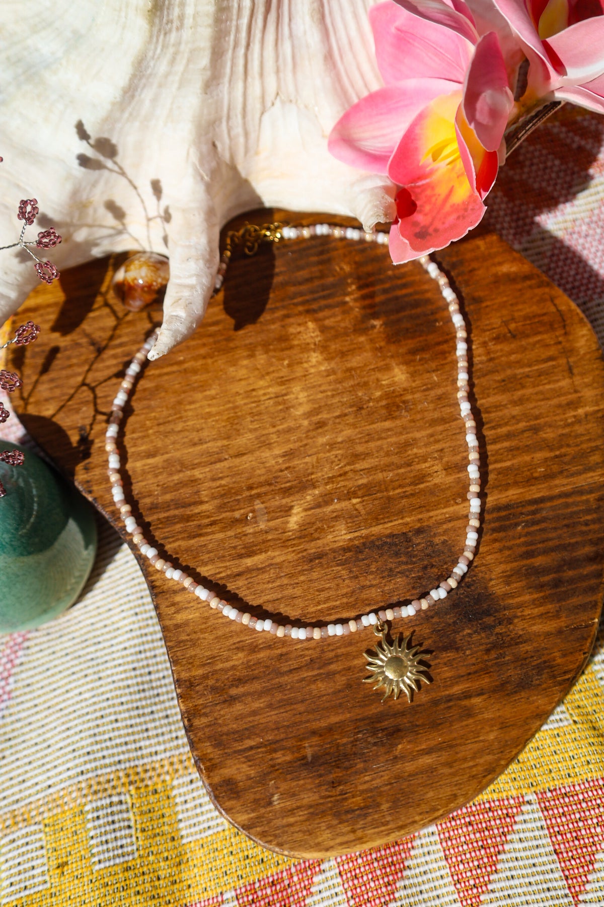 Collier perles rocailles marrons et blancs avec pendentif soleil doré