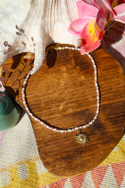 Collier perles rocailles marrons et blancs avec pendentif soleil doré