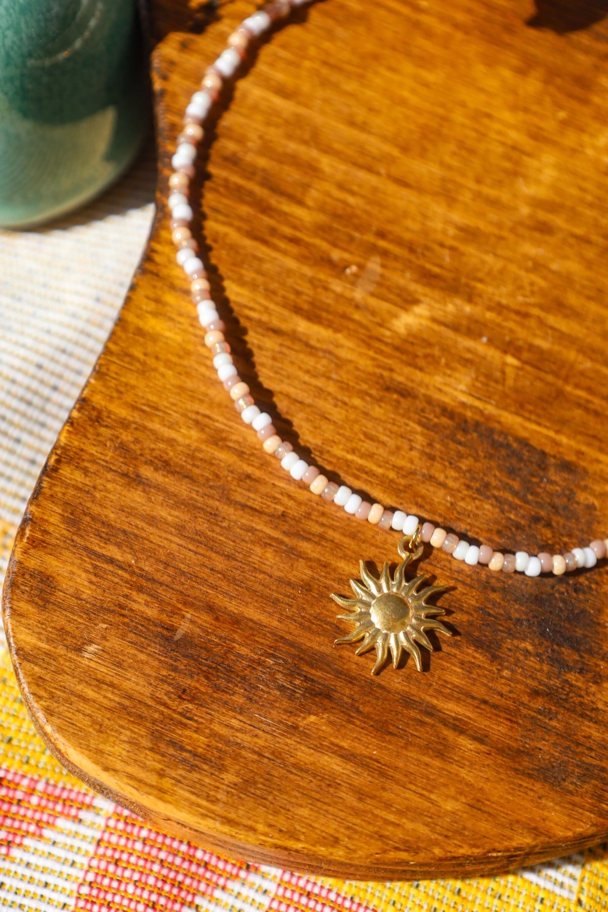 Collier perles rocailles marrons et blancs avec pendentif soleil doré