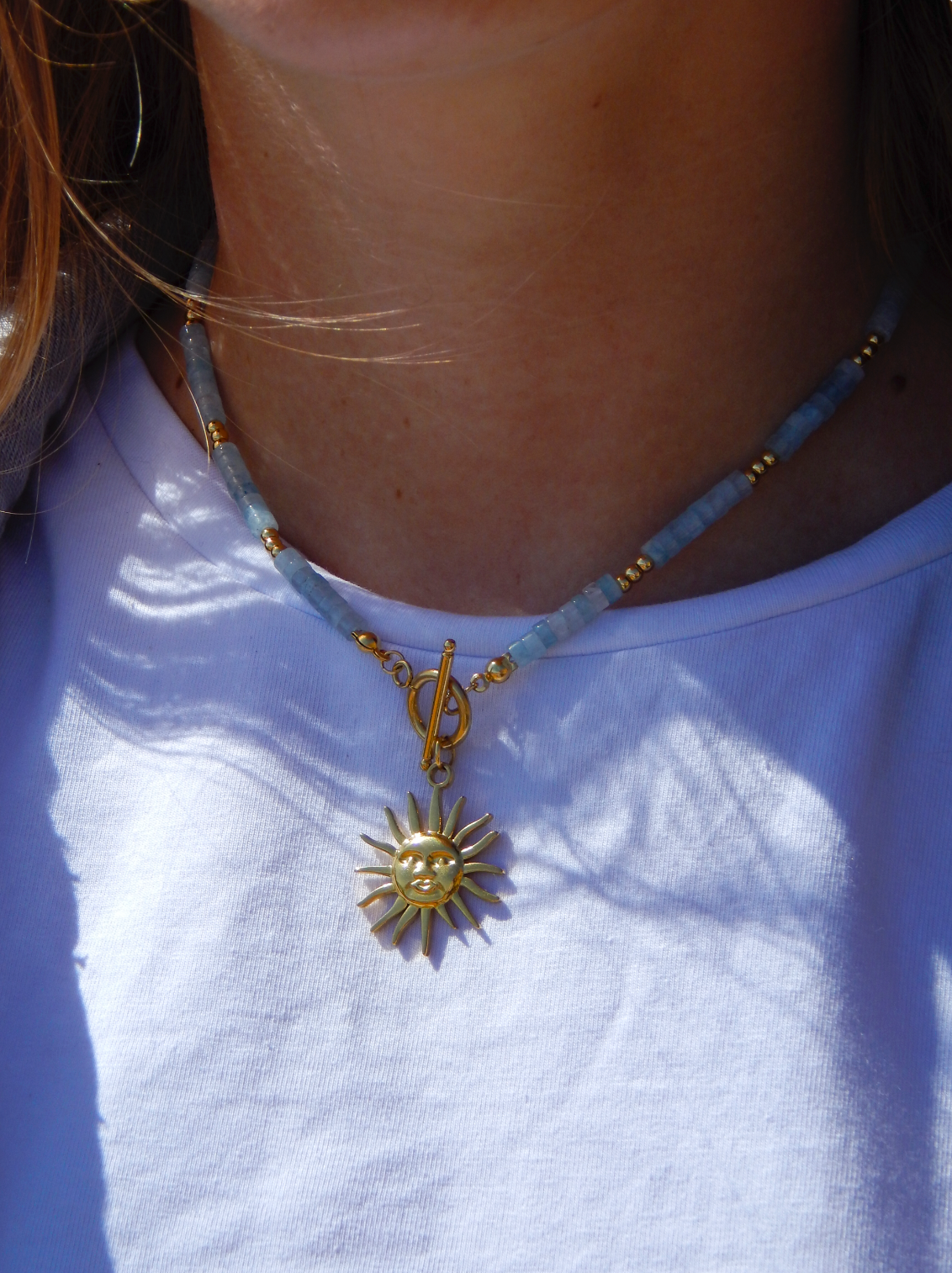 Collier en perles d'aigues marine avec un pendentif soleil en acier inoxydable