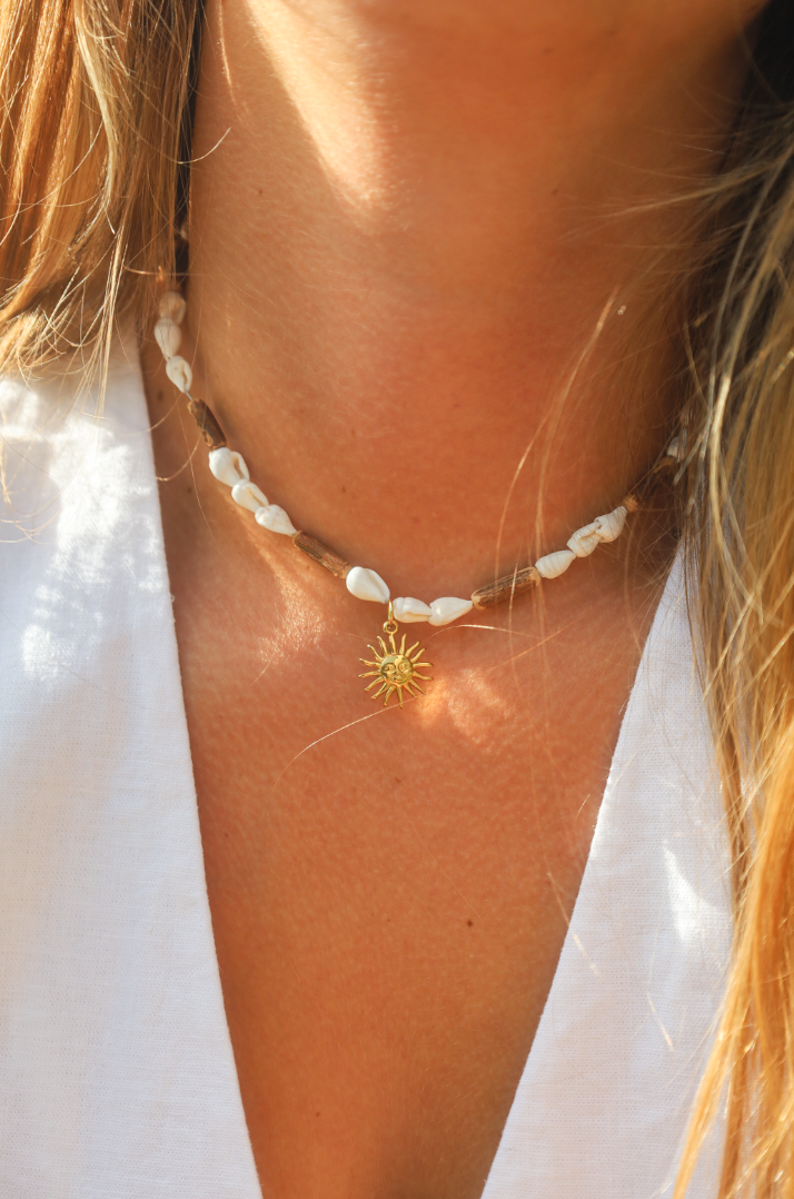 Collier en coquillages blancs et perles en bois naturel avec petit pendentif soleil