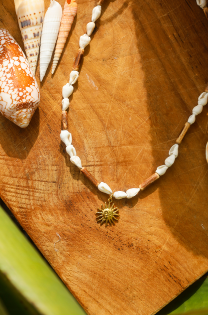 Collier en coquillages blancs et perles en bois naturel avec petit pendentif soleil
