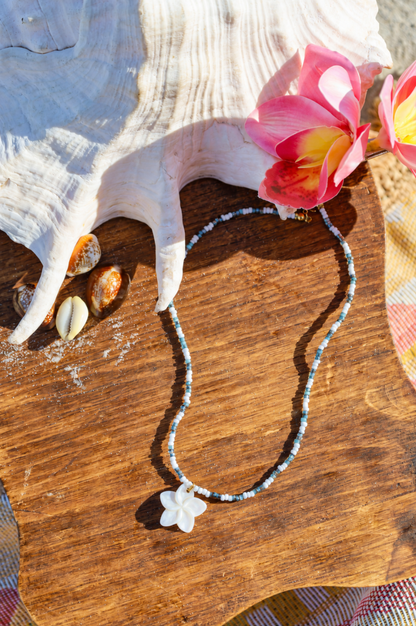 Collier composé de perles de petites rocailles de différentes couleur avec pendentif fleur en nacre