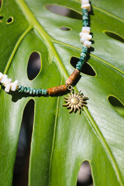 Collier en perles de jades vertes et en perles naturelles blanches avec pendentif soleil.