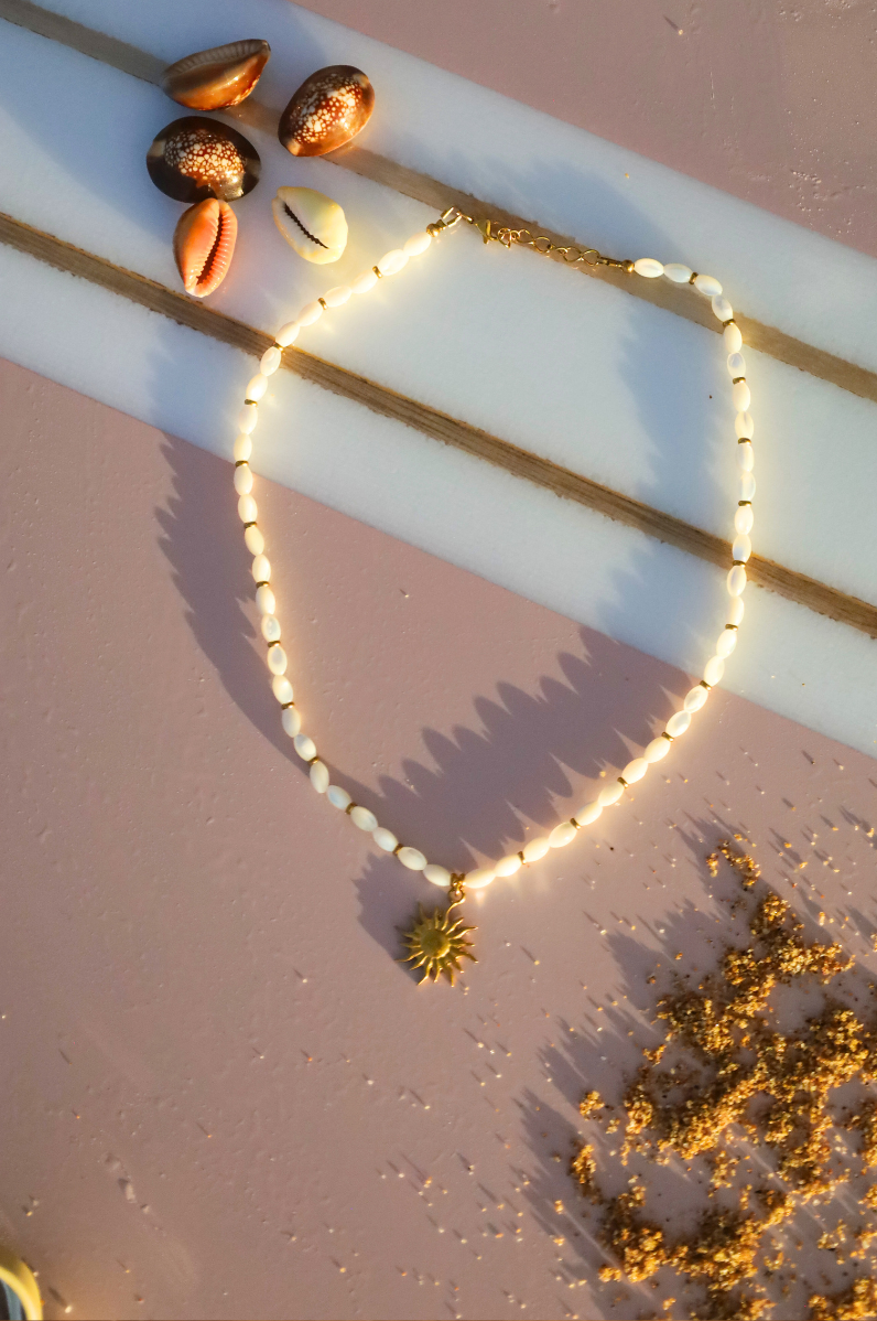 Collier en nacres olives et pendentif doré soleil