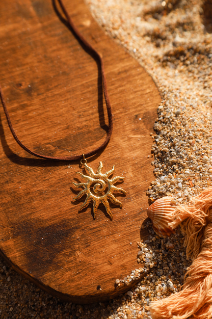 collier en suédine marron et pendentif soleil doré