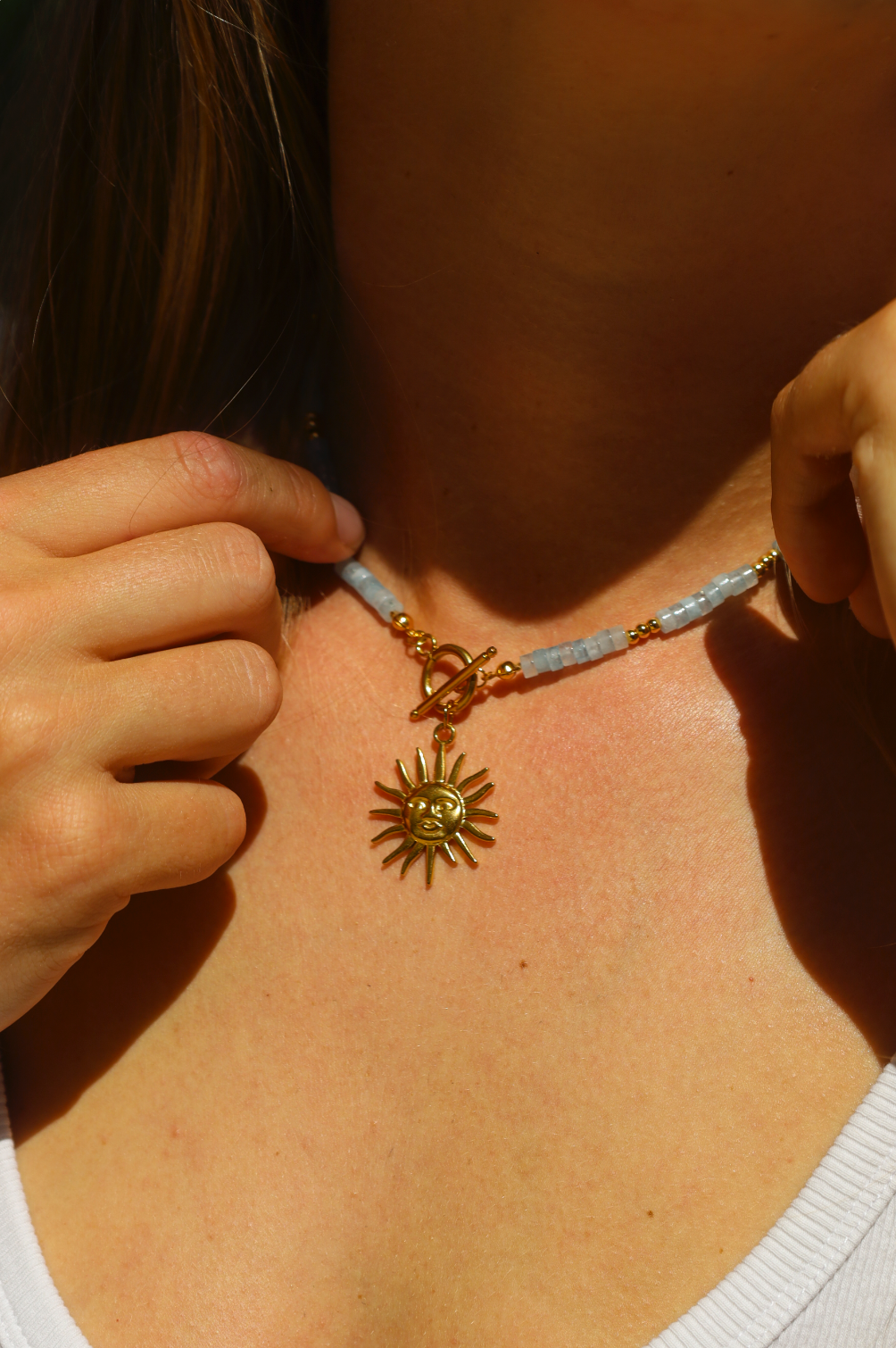 Collier en perles d'aigues marine avec un pendentif soleil en acier inoxydable