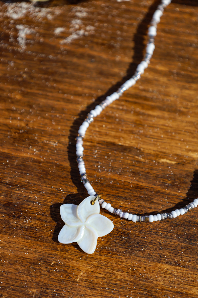 Collier composé de perles de petites rocailles de différentes couleur avec pendentif fleur nacre